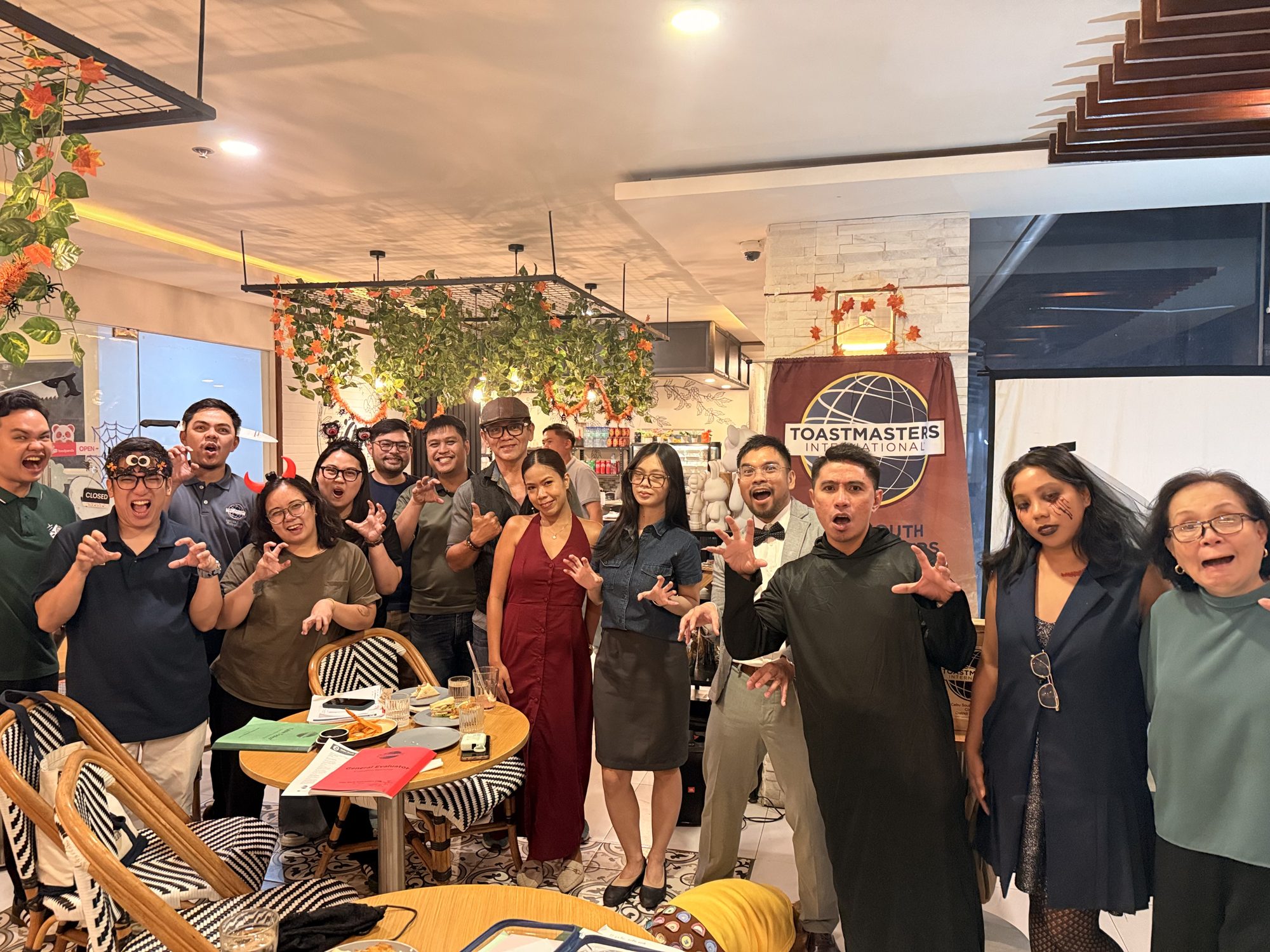 Cebu South Toastmasters members in Halloween costumes making scary faces at Te'Amo Café